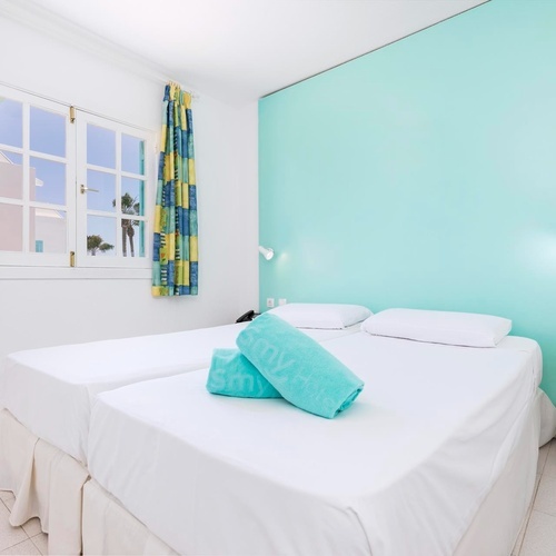 ein Schlafzimmer mit zwei Betten und einer blauen Wand