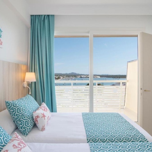 um quarto com duas camas e uma varanda com vista para o oceano