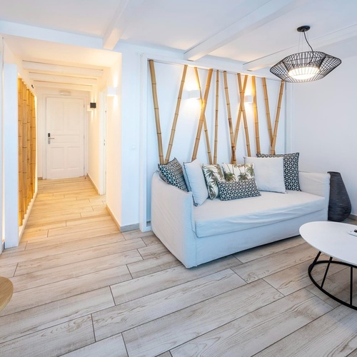 un salon avec un canapé blanc et une télévision