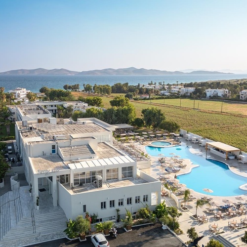 an aerial view of a hotel with a large pool