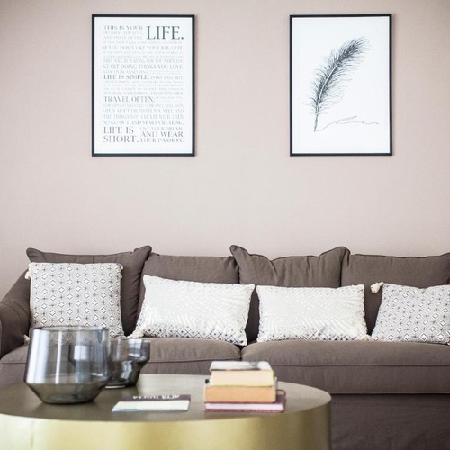 ein Wohnzimmer mit einer Couch und zwei Bildern an der Wand