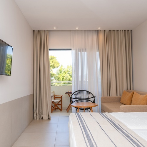 a hotel room with a couch and a flat screen tv