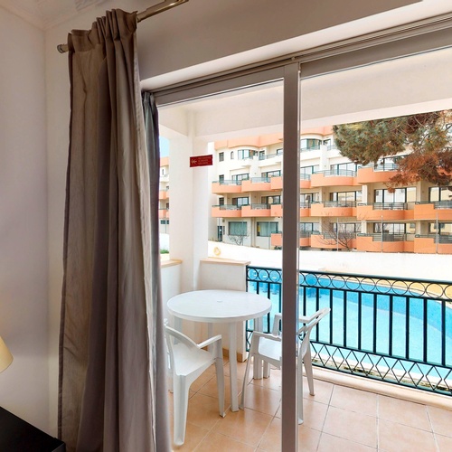 a sliding glass door leading to a balcony with a table and chairs