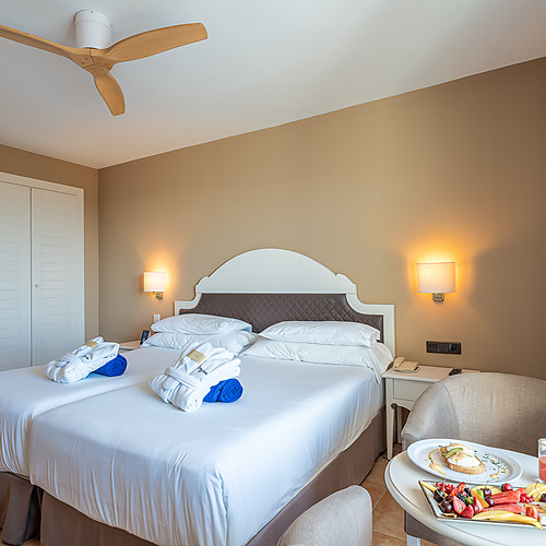 Smy: Corporativa Suite mit Wohnbereich und hellem Schlafzimmer.