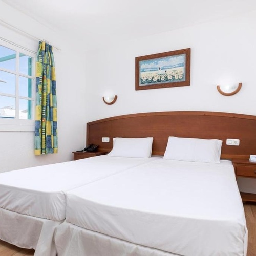 ein Schlafzimmer mit zwei Betten und einem Gemälde an der Wand