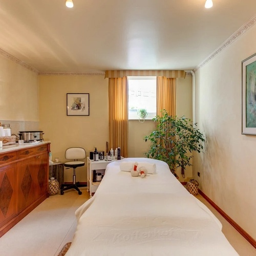 a massage table in a room with a painting on the wall