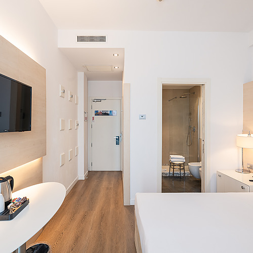 Chambre Smy: Corporative avec lit confortable et lampes de table.
