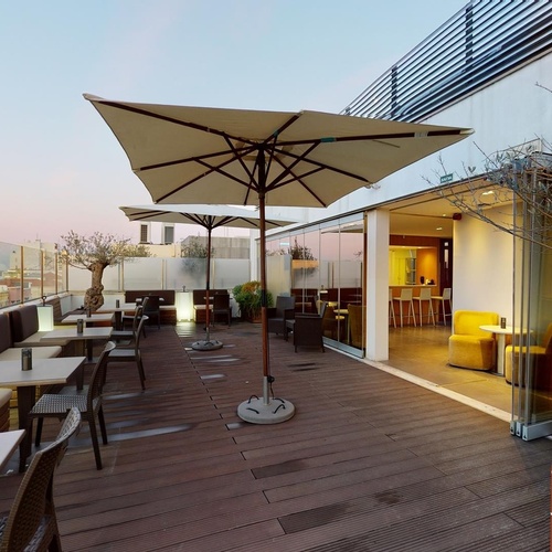 a patio with tables and umbrellas and a sign that says ' a ' on it