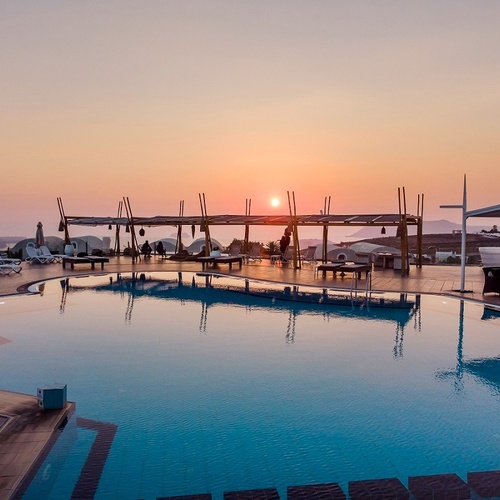 ein großer Pool mit Sonnenuntergang im Hintergrund