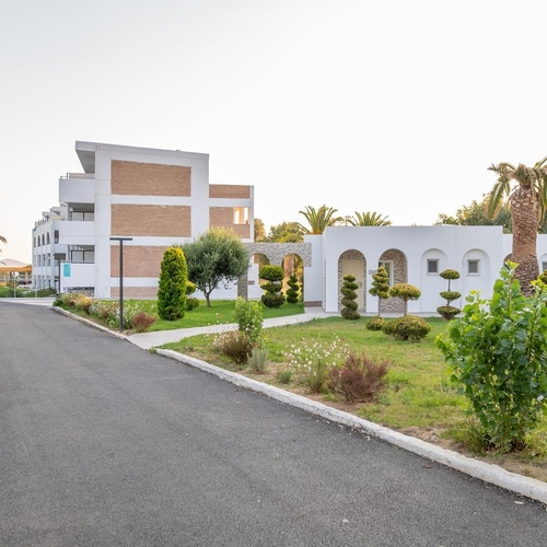 a white building with a few trees in front of it