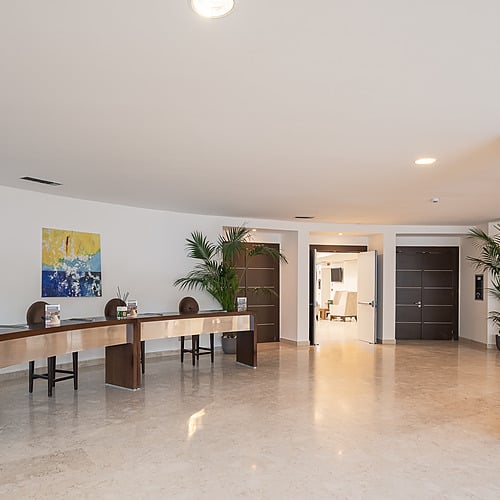 Réception d'hôtel moderne, un long comptoir en bois avec des chaises et une peinture abstraite. Photo de l'intérieur Smy: Corporativa.
