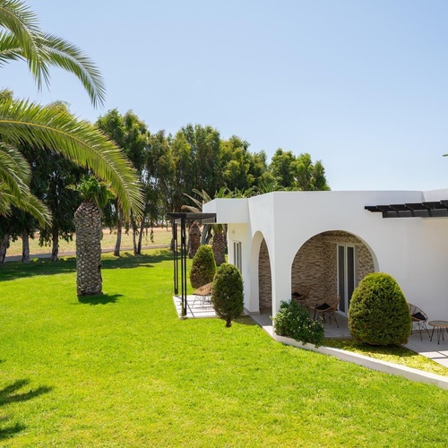 a white house with a lush green lawn in front of it