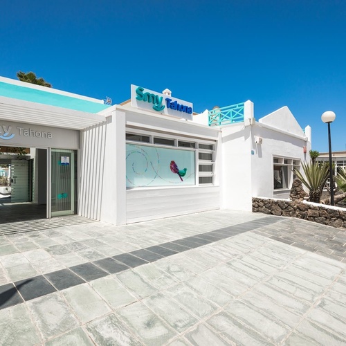 ein weißes Gebäude mit einem blauen Schild auf der Seite , das sagt smv teleone