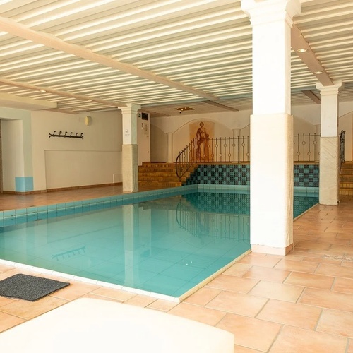 a large indoor swimming pool with a painting on the wall