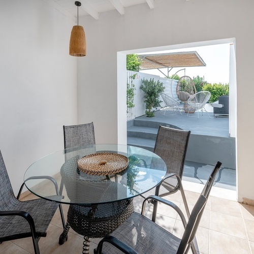 a dining area with a glass table and chairs