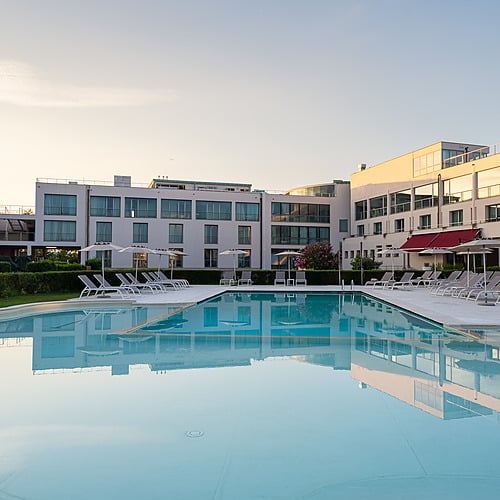 Piscine et hôtel moderne avec des chaises longues, idéal pour votre Smy: Corporativa.