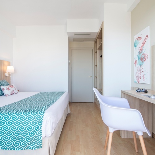 um quarto de hotel com uma cama e uma mesa