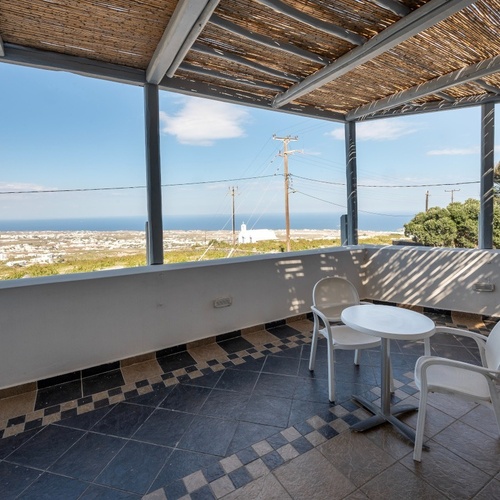 ein Balkon mit Tisch und Stühlen mit Blick auf den Ozean