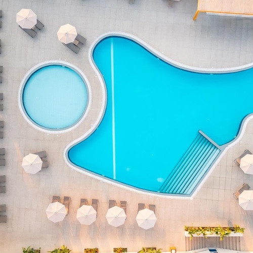 una vista aérea de una piscina rodeada de sillas y sombrillas