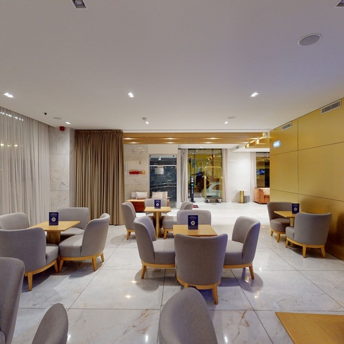 a room with tables and chairs and a sign that says smv hotels