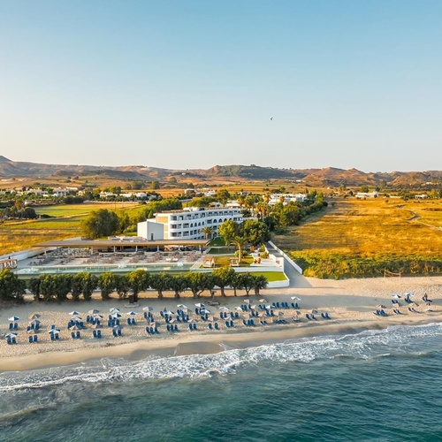 an aerial view of a beach with umbrellas and chairs