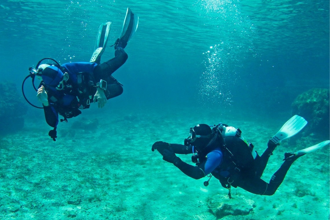 a glass of red liquid with a straw on the beach