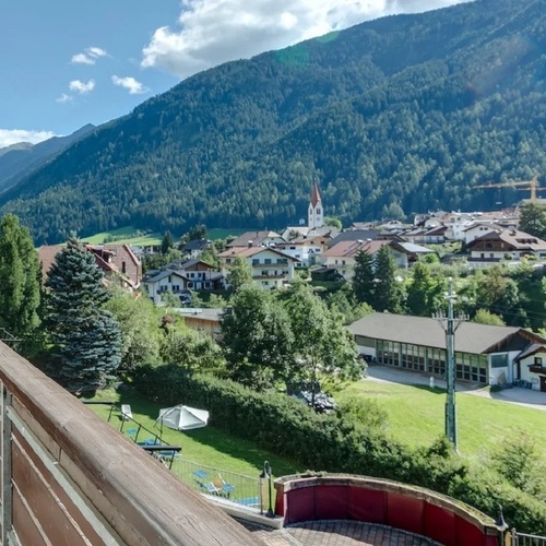 a balcony overlooking a small town with mountains in the background