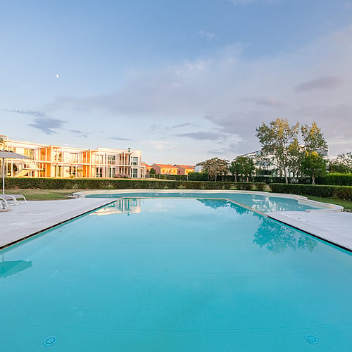 Piscine extérieure d'un hôtel avec chaises longues et parasol, idéal pour Smy: Corporativa.