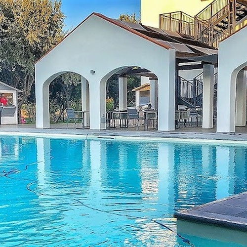 ein großer Swimmingpool mit weißen Gebäuden dahinter