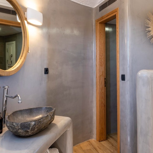 une salle de bain avec un lavabo en pierre et un miroir