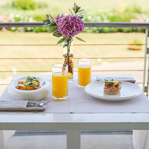 Petit-déjeuner sur le balcon : toasts à l'avocat, tartare de poisson et jus d'orange pour Smy: Corporativa.