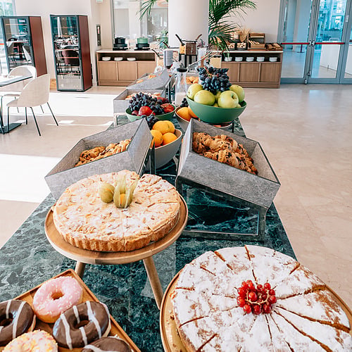 Buffet de petit-déjeuner avec tartes, beignets et fruits frais. Smy: Corporativa.