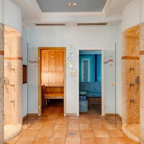 a bathroom with showers and a sauna with a sign that says ' sauna ' on it