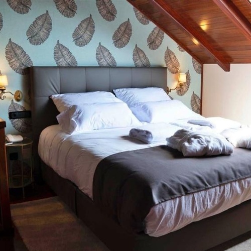 una habitación con una cama y un papel pintado de hojas