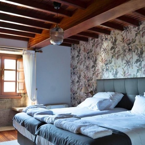 una habitación con dos camas y una ventana