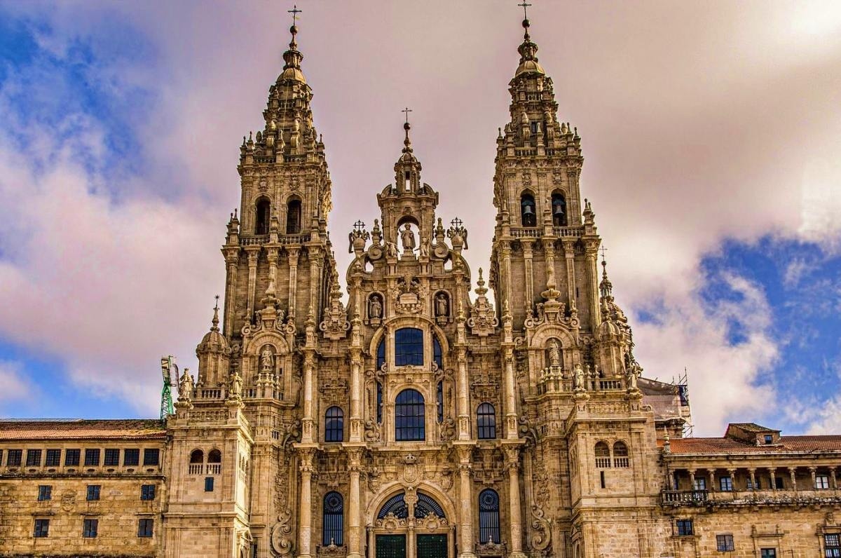 un gran edificio de piedra con balcones y mesas y sillas al frente