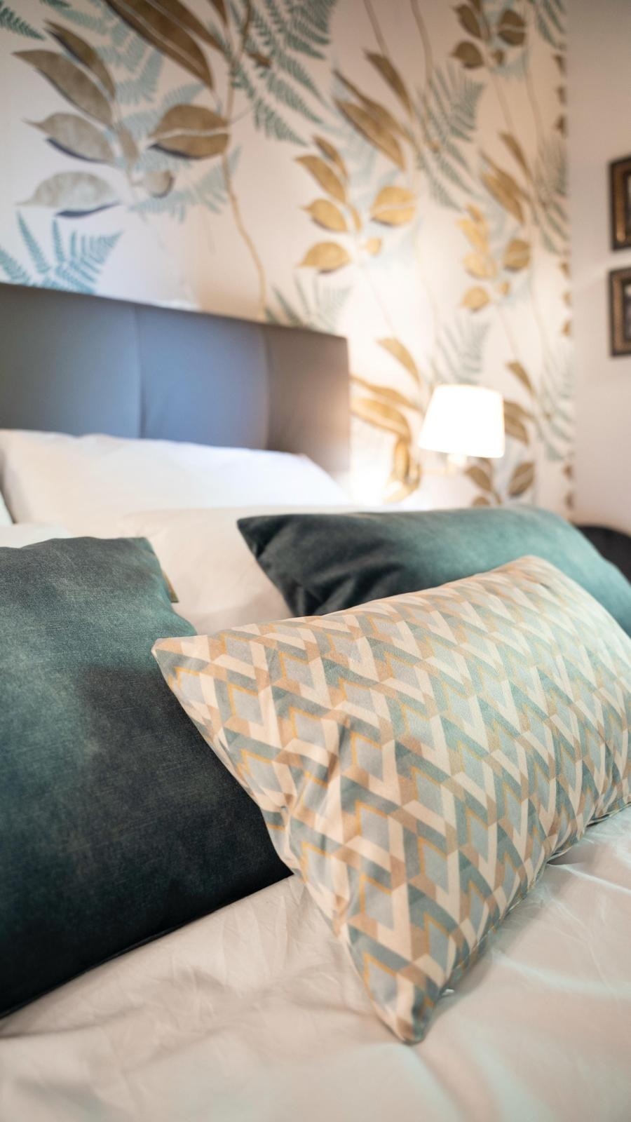 un primer plano de una cama con almohadas y una lámpara