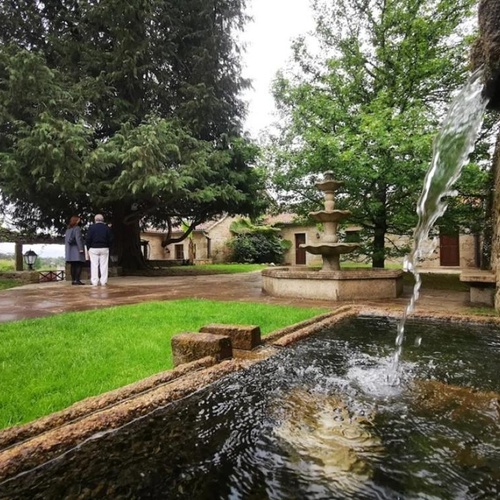 un hombre y una mujer se paran frente a una fuente de agua
