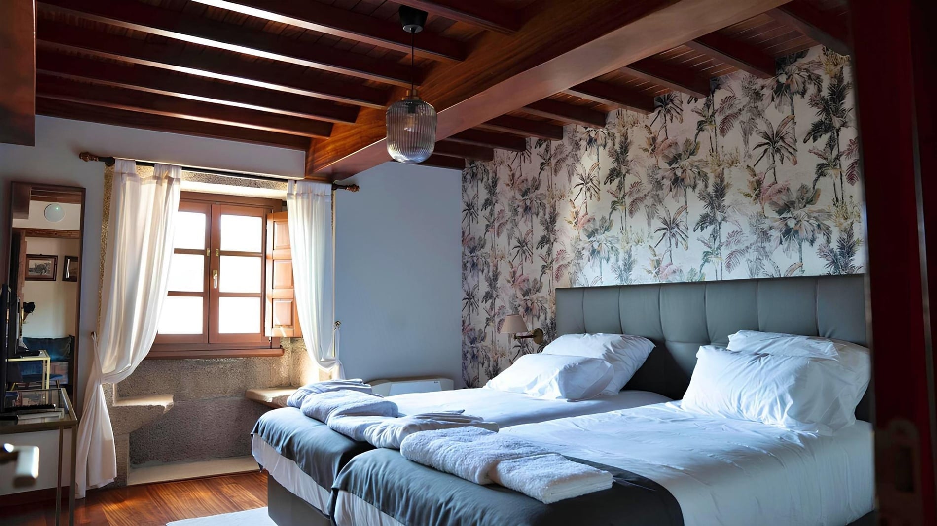 una habitación con dos camas y un techo de madera