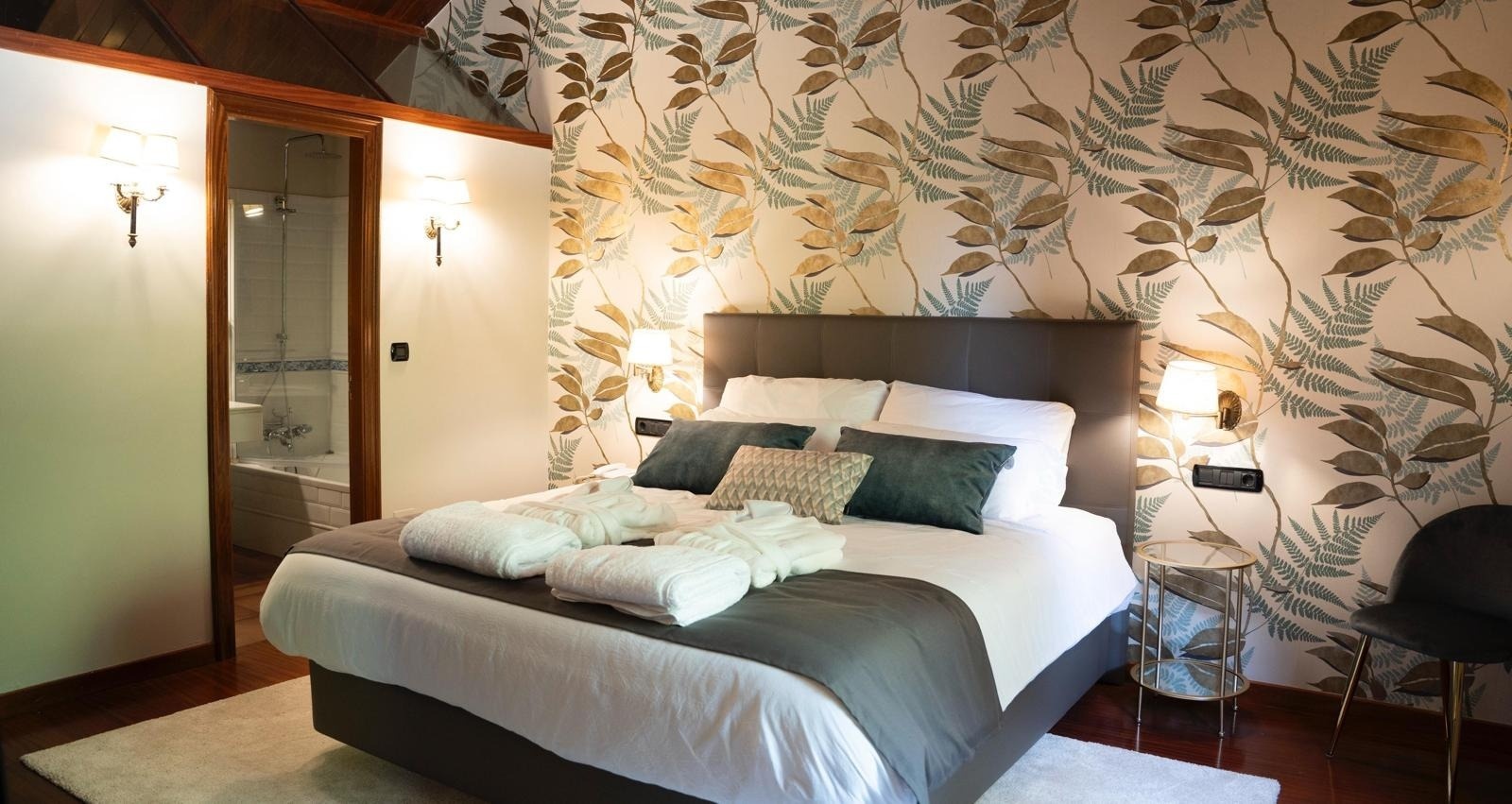 una habitación con una cama y una pared con hojas