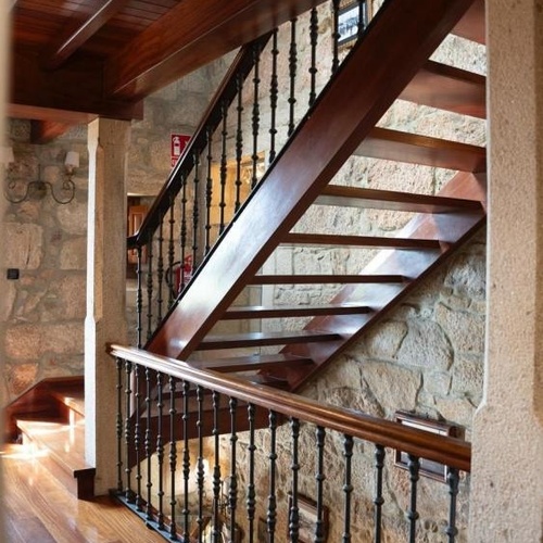 una escalera de madera con una barandilla de hierro forjado