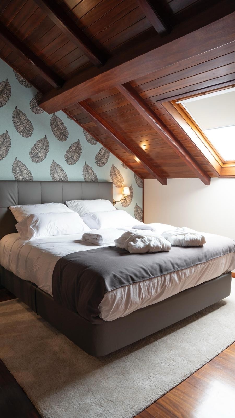 un dormitorio con una cama y un techo de madera