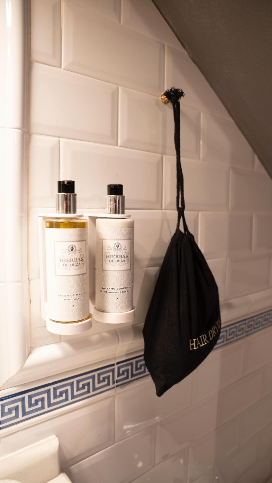 dos botellas de hierbas de ibiza están en un estante en un baño