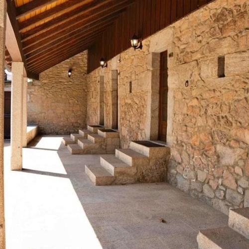 un porche de piedra con escaleras y techo de madera