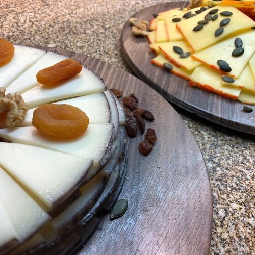 Queso y frutos secos en tabla de madera, ideal para SNÖ Aragón Hills.