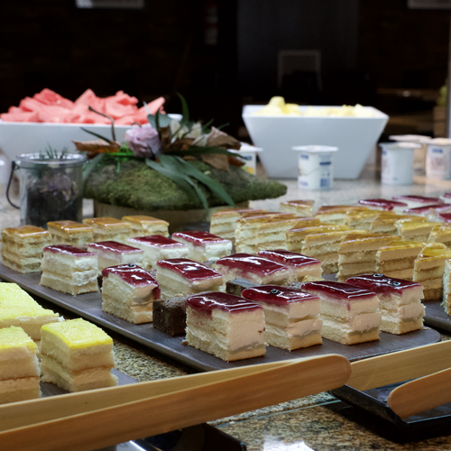 Delicioso buffet de postres y desayuno en hotel con pasteles, frutas y yogures.