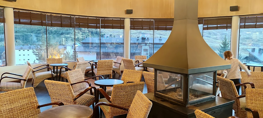 una habitación con muchas mesas y sillas y una chimenea