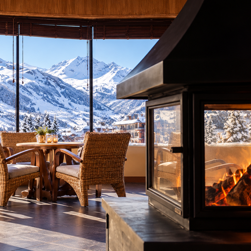 Interior acogedor con chimenea y vistas a las montañas de SNO: Aragon Hills.