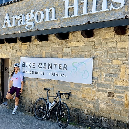 Ciclista posa frente a Bike Center, Aragón Hills SNO: Aragon Hills, Formigal