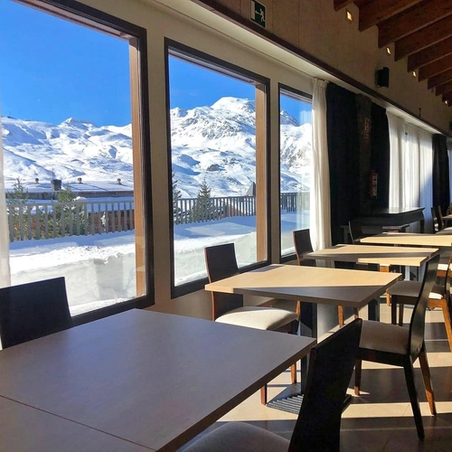 Dos mujeres brindan en la terraza de SNO: Aragon Hills, con vistas a las montañas.